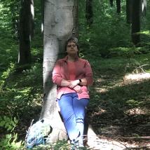 Frau lehnt sich an Baum und entspannt sich