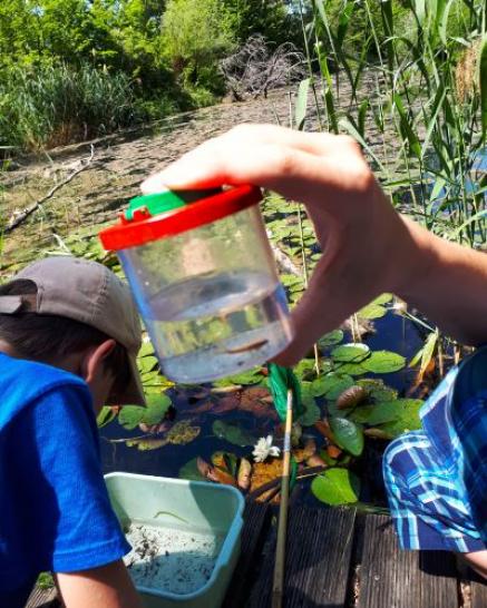 Becherlupe und Kinder im Hintergrund