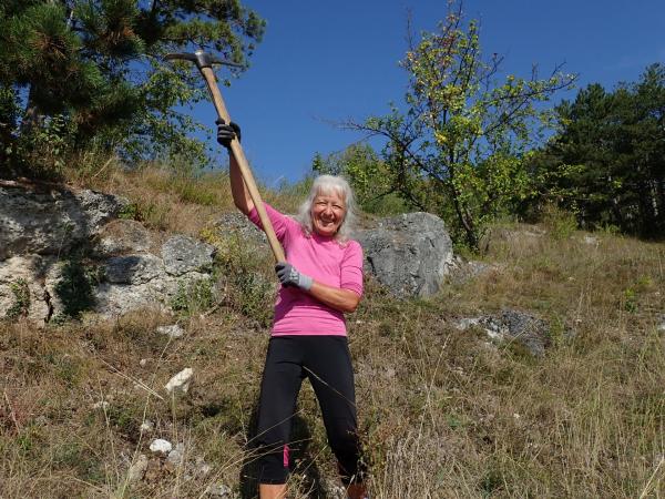 Frau mit Werkzeug in Trockenrasenlandschaft