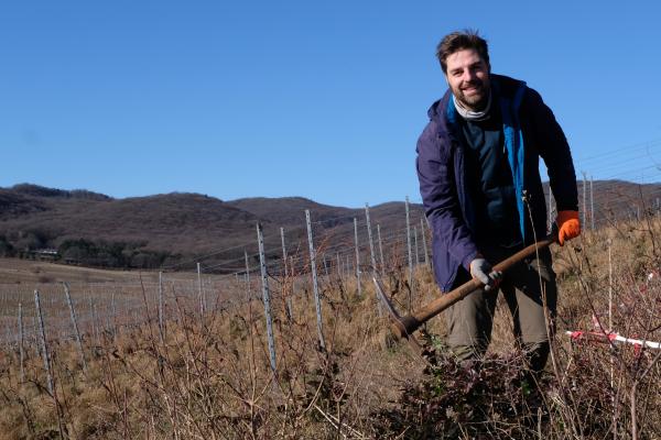 Mann mit Werkzeug, Landschaft im Hintergrund