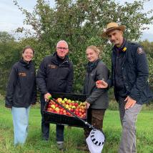 Personengruppe mit Äpfeln auf Streuobstwiese